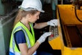 Woman engineer wear hardhat working at machine in factory. female technician control metalwork lathe industrial. female employee Royalty Free Stock Photo