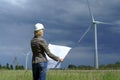 Woman engineer with white safety hat wind turbine