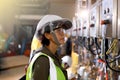Woman Engineers electrical control with safety helmet and safety glasses for industrial estate or power plant background. Industry