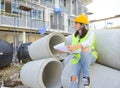 Woman engineers holding blueprint at construction site