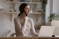 Woman enjoy conversation sits in kitchen at table with laptop