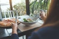 Woman enjoy eating Ceasar salad and pizza in the restaurant Royalty Free Stock Photo