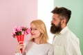 Woman enjoy fragrance bouquet flowers. Couple in love happy celebrate anniversary. Man with beard takes care about Royalty Free Stock Photo