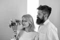 Woman enjoy fragrance bouquet flowers. Couple in love happy celebrate anniversary. Man with beard takes care about Royalty Free Stock Photo