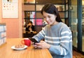 Woman enjoy her morning breakfast with her cellphone Royalty Free Stock Photo