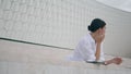 Woman enjoy work break outdoors leaning fence in earbuds. Girl listening music.