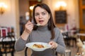 Woman enjoying apple strudel with vanilla sauce in coffee house Royalty Free Stock Photo