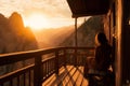 woman enjoying a beautiful sunset, sitting on a deck. Vast spaces of seas and oceans are located around her