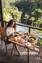 Woman enjoying breakfast, terrace with jungle view Royalty Free Stock Photo