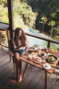 Woman enjoying breakfast, terrace with jungle view