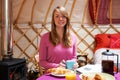 Woman Enjoying Breakfast Whilst Camping In Traditional Yurt Royalty Free Stock Photo