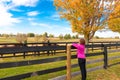 Woman enjoying countryside view with horses in autumn season