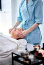 Woman enjoying facial massage. Pretty female getting professional skin care at wellness center