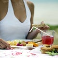 Woman enjoying her meal by the beach side. Conceptual image