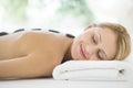 Woman Enjoying Hot Stone Therapy At Beauty Spa