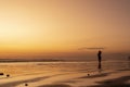 Woman enjoying life on the beach at sunset. Silhouette of young woman standing feeling free Royalty Free Stock Photo