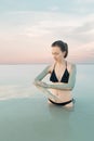 Woman enjoying the natural mud mineral source on dead sea background Royalty Free Stock Photo