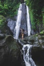 Woman enjoying near hidden in jungle cascade waterfall Dusun Kuning in Bali Royalty Free Stock Photo