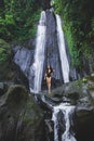 Woman enjoying near hidden in jungle cascade waterfall Dusun Kuning in Bali Royalty Free Stock Photo