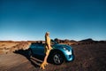 Woman enjoying road trip, standing with map near convertible car on the roadside in the volcanic mountain forest on Tenerife Royalty Free Stock Photo