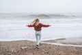 Woman enjoying stormy sea running on beach Royalty Free Stock Photo