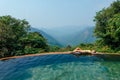 Woman enjoying a sun in the infinity pool in eco plastic free zone ,mountain and hills background Royalty Free Stock Photo