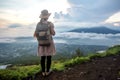 Woman enjoying sunrise from a top of mountain Batur, Bali, Indonesia