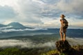 Woman enjoying sunrise from a top of mountain Batur, Bali, Indonesia