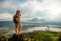 Woman enjoying sunrise from a top of mountain Batur, Bali, Indonesia