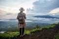 Woman enjoying sunrise from a top of mountain Batur, Bali, Indonesia