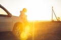 woman enjoying of sunset ar countryside. standing near white SUV Royalty Free Stock Photo