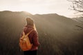 Woman enjoying the sunset in nature on the edge of a rock cliff. Woman hiker enjoys mountains view. Royalty Free Stock Photo