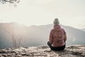 Woman enjoying the sunset in nature on the edge of a rock cliff. Woman hiker enjoys mountains view. Royalty Free Stock Photo