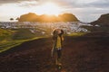 Woman enjoying sunset on peak Eldfell volcano with view of Vestmannaeyjar island