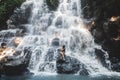 Woman enjoying under stream of big and beautiful cascade waterfall Kanto Lampo