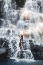 Woman enjoying under stream of big and beautiful cascade waterfall Kanto Lampo