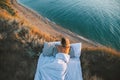 Woman enjoying view on beach landscape while relaxing in bed in sunset on the edge of Earth Royalty Free Stock Photo