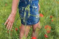 Woman enjoying a walk in a poppy field under the summer sun. Royalty Free Stock Photo