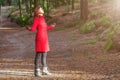 Woman enjoying the warmth of winter sunlight alone on forest park path with arms open Royalty Free Stock Photo