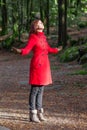 Woman enjoying the warmth of the winter sunlight on a forest