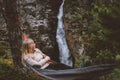 Woman enjoying waterfall view lying in hammock in forest travel lifestyle outdoor with camping gear Royalty Free Stock Photo