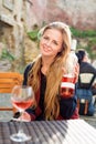 Woman enjoying wine in outdoor restaurant. Portrait of a beautiful wine tasting tourist girl. Royalty Free Stock Photo