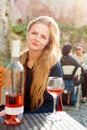 Woman enjoying wine in outdoor restaurant. Portrait of a beautiful wine tasting tourist girl. Royalty Free Stock Photo