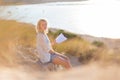 Woman enjoys reading on beautiful sandy beach. Royalty Free Stock Photo