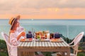 Woman enjoys romantic dinner for two on the beach at sunset Royalty Free Stock Photo