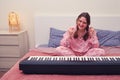 A woman enjoys the success of playing the piano in the home bedroom, the exultation of a musician