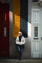 A woman enjoys the sunlight while standing outside a traditional Portuguese town house. Royalty Free Stock Photo