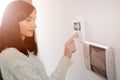 Woman entering code on keypad of home security alarm