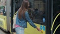 Woman entering the door of the modern tram at the station.