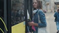 Woman entering the door of the modern tram at the station.